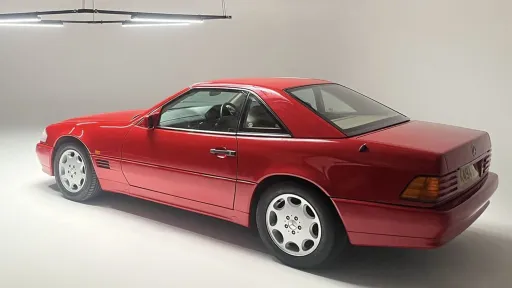 Rear three-quarter view of red Mercedes-Benz SL R129 convertible photographed in studio